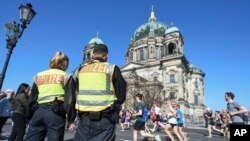 Maafisa wa polisi wakilinda doria katika mbio za nusu -marathon mbele ya Kanisa la Berlin, Berlin, Ujerumani, April 8, 2018. 