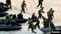 Japan Self-Defense Force (JSDF) soldiers land on Eniyabanare Island during a military drill, off Setouchi town on the southern Japanese island of Amami Oshima, Kagoshima prefecture, in this photo taken by Kyodo, May 22, 2014. 