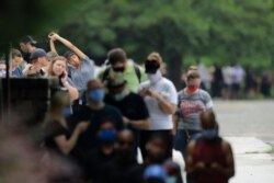 A person stretches as voters wait in a line in Georgia's primary election at Park Tavern in Atlanta, June 9, 2020.