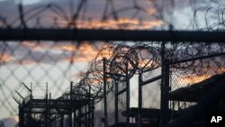 FILE - Dawn breaks at the now closed Camp X-Ray, used as the first detention facility for suspected militants captured after the Sept. 11 attacks, at the Guantanamo Bay Naval Base in Cuba.