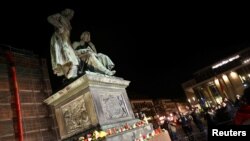 Candles are placed around the Brothers Grimm monument during a vigil for the victims of a shooting in Hanau, near Frankfurt, Germany, Feb. 20, 2020.