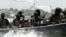 FILE - Militants with Kalashnikov assault rifles and rocket-propelled grenade launchers patrol creeks of the Niger Delta, southern Nigeria, Feb. 24, 2006.