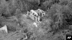 FILE - In this Jan. 8, 1970, file photo, paths marked off with white tape strung between metal stakes relay the remains of homes in My Lai, Vietnam. The paths have been cleared of booby traps so that investigators can move around the hamlet in relative security. On March 16, 1968, U.S soldiers of Charlie Company, sent on what they were told was a mission to confront a crack outfit of their Vietcong enemies, met no resistance, but over the course of three to four hours killed 504 unarmed civilians, mostly women, children and the elderly, in My Lai and a neighboring community. 
