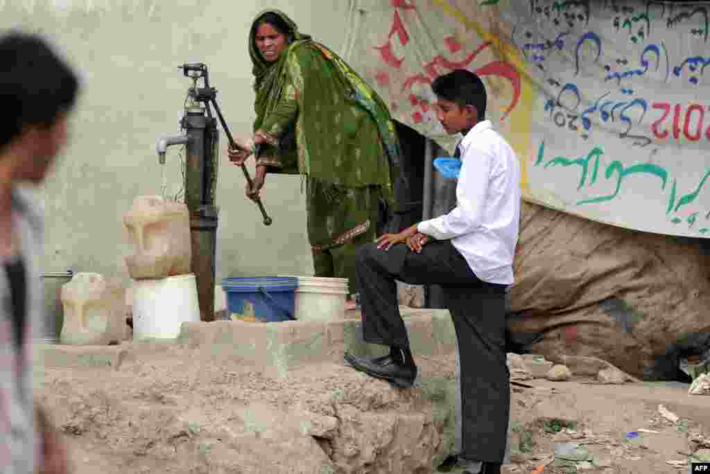 A Pakistani Christian woman fills jerry cans with water from a hand pump at a slum area of Islamabad.