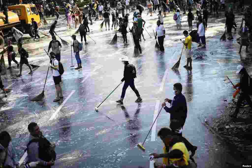 Anti-government protesters sweep the street around the Democracy Monument after weeks of protesting and days of clashes with police in Bangkok&#39;s city center, Dec. 4, 2013.
