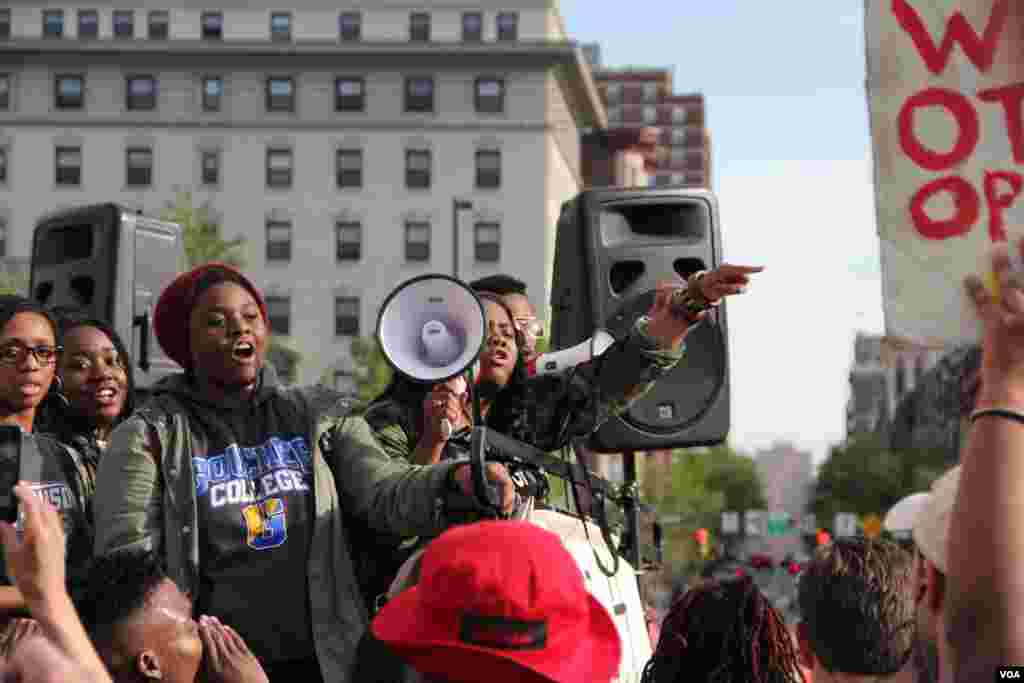 Towson University student Korey Johnson shouts through the megaphone to a trail of 1000 high school and college students, who marched from Baltimore’s Penn Station to City Hall. (Victoria Macchi/VOA News)