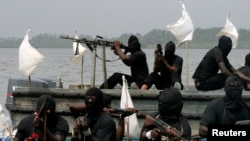 FILE - Militants are seen patrolling the creeks of the Niger delta region of Nigeria, Jan. 30, 2007. 