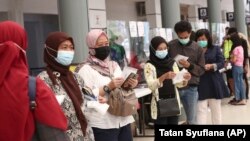Para calon penumpang antre untuk tes virus corona untuk perjalanan kereta jarak jauh di Stasiun Pasar Senen, Jakarta, 9 Februari 2021. (Foto: Tatan Syuflana/AP)