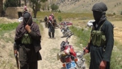 FILE - Taliban fighters stand with their weapons in Ahmad Aba district, on the outskirts of Gardez, the capital of Paktia province, Afghanistan, July 18, 2017.