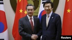 지난해 3월 서울에서 열린 한·중 외교장관 회담에서 윤병세 한국 외교장관(오른쪽)과 왕이 중국 외교부장이 악수하고 있다. (자료사진)