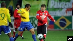 Chechnya leader Ramzan Kadyrov (r) fights for the ball with Brazil's 2002 World Cup-winning side player Dunga (c) during an exhibition match between Brazil's 2002 World Cup-winning side and 'team Kadyrov' in Grozny on March 8, 2011