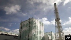 Tokyo Electric Power Co. (TEPCO)'s tsunami-crippled Fukushima Daiichi nuclear power plant No.6 (L) and No.5 reactor buildings are seen from a bus window in Fukushima prefecture, File February 20, 2012