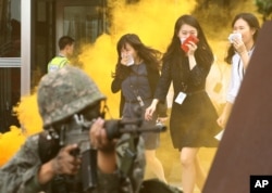 FILE - People evacuate a building during a U.S.-South Korean drill against possible attacks by North Korea as part of the annual Ulchi Freedom Guardian exercise in Seoul, South Korea, Aug. 20, 2014.