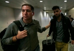 FILE - U.S. journalist Glenn Greenwald (L) walks with his partner David Miranda in Rio de Janeiro's International Airport, August 19, 2013.