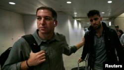 Wartawan AS Glenn Greenwald (kiri) dan pasangannya David Miranda di bandara Rio de Janeiro, 19 Agustus 2013. 
