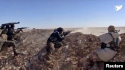 This photo from a video provided by the Syria Democratic Forces (SDF), shows fighters from the SDF opening fire on an Islamic State group's position, in Raqqa's eastern countryside, Syria, March 6, 2017. 