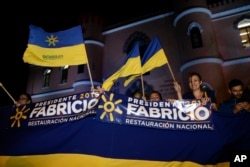 Supporters of presidential candidate Fabricio Alvarado with the National Restoration party gather before a debate ahead of the presidential election in San Jose, Costa Rica, Feb. 1, 2018.