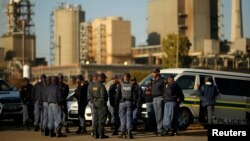 FILE - Police officers stand outside the Lonmin mine in Rustenburg, South Africa, May 14, 2014.