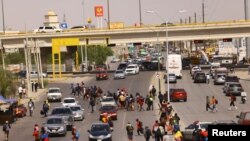 Migrants cross a road, in Ciudad Juarez, Mexico Sept. 20, 2023. With more migrants arriving at the U.S. border with Mexico, the Biden administration said Wednesday that it was granting temporary legal status to hundreds of thousands of Venezuelans who are already in the country.