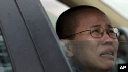 Liu Xia, wife of imprisoned Nobel Peace Prize winner Liu Xiaobo, cries in a car outside Huairou Detention Center where her brother Liu Hui has been jailed in Huairou district, on the outskirts of Beijing, China, Sunday, June 9, 2013. A court sentenced Liu