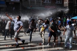 Nepalese protesters defying a government coronavirus lockdown to take part in a religious festival clash with riot police, in Lalitpur, Nepal, Sept. 3, 2020.