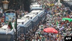 Algerian riot policemen stand guard as protesters gather during a weekly demonstration coinciding with the Algerian independence day in the capital Algiers, July 5, 2019. 