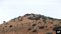 Freshly dug graves that contain the remains of Rhonita Miller and four of her young children are overspread with flowers a day after their burials in Colonia LeBaron, Mexico, Nov. 9, 2019. 