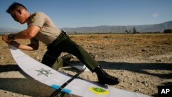 FILE - A Los Angeles County Sheriff's Deputy assembles an autonomous drone aircraft used by the military and law enforcement, during a demonstration June 16, 2006, in Redlands, Calif.