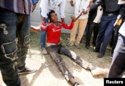 People assist an injured protester during Irrechaa, the thanksgiving festival of the Oromo people, in Bishoftu, Ethiopia, Oct. 2, 2016.