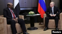 Russian President Vladimir Putin talks with Sudan's President Omar al-Bashir during their meeting in the Black Sea resort of Sochi, Russia, Nov. 23, 2017. 