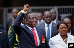 FILE - Emmerson Mnangagwa, center, and his wife, Auxillia, right, arrive at the presidential inauguration ceremony in Harare, Zimbabwe, Nov. 24, 2017.