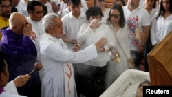 FILE - A priest performs last rites during the funeral mass for Filipino Mayor Antonio Cando Halili, who was assassinated while attending a flag ceremony last Monday, in Tanauan, Batangas, in Philippines, July 8, 2018. 