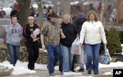 Des parents et élèves passent devant l'Ecole primaire de Chardon, proche du lycée où a eu lieu la fusillade (27 fév. 2012)