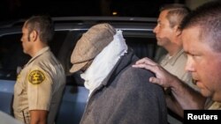 Nakoula Basseley Nakoula (tengah) dikawal keluar dari rumahnya oleh petugas berwenang di Los Angeles (15/9). (Reuters)