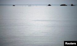 FILE - A fishing boat motors back to shore on the east coast of Natuna Besar.