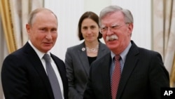 FILE - Russian President Vladimir Putin, left, and U.S. national security adviser John Bolton shake hands during their meeting in the Kremlin in Moscow, Oct. 23, 2018.