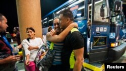 FILE - Cuban migrant Mailin Perez is greeted by her husband, Jose Caballero, after arriving at a bus station in Texas, via Mexico, in this 2014 photo.