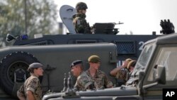 British troops stand near their vehicles after crossing the border from Bulgaria in Giurgiu, Romania, June 1, 2017 to take part in the alliance's Noble Jump 2017 exercise.