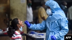 បុគ្គលិកសុខភិបាលកំពុងយកសំណាកដើម្បីធ្វើតេស្តរកវីរុសកូរ៉ូណាពីពលរដ្ឋរស់នៅទីក្រុង Mumbia ប្រទេសឥណ្ឌា កាលពីថ្ងៃទី១៦ ខែកក្កដា ឆ្នាំ២០២០។ 