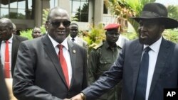 Wakil Presiden Sudan Selatan Riek Machar (kiri) dan Presiden Salva Kiir berjabat tangan usai pertemuan di Juba (foto: dok).