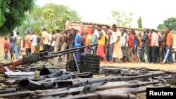 FILE - Suspected fighters are paraded before the media by Burundian police near a recovered cache of weapons after clashes in the capital Bujumbura, Burundi, Dec. 12, 2015.