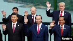 FILE- Leaders pose during the photo session at the APEC Summit in Danang, Vietnam, Nov. 11, 2017. Front left, China's President Xi Jinping. Rear center and right, Russia's President Vladimir Putin, U.S. President Donald Trump. 