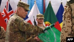 Tướng John Campbell (trái) cuộn lá cờ của Lực lượng Hỗ trợ An ninh Quốc tế do NATO dẫn đầu (ISAF) trong buổi lễ đánh dấu sự kết thúc sứ mệnh chiến đấu của ISAF tại Afghanistan, ngày 28/12/2014.