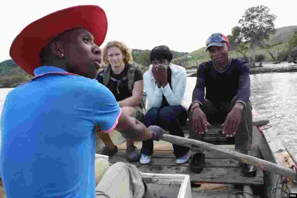 The ferryman rows the boat across the Xhora River … From left to right are American medical student Sam Partington and Buselwa Senyuko and Bongesi Gashe, who must journey to a distant clinic for medical help. (VOA/D.Taylor)