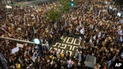 People march in a protest in Tel Aviv, Israel, Nov. 9, 2024 against Prime Minister Benjamin Netanyahu's government and call for the release of hostages held in the Gaza Strip by the Hamas militant group, marking 400 days since their capture. 