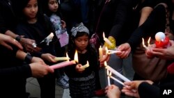 A girl among people during a vigil, outside of the presidential palace in Nicosia, Cyprus, April 26, 2019. 