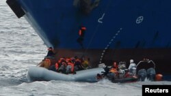 Des migrants s’approchent d’un bateau de secours de l’ONG Migrant Offshore Aid Station, dans les eaux internationales de la Méditerranée au large de la Libye, le 16 avril 2017.