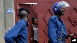 Une habitante sort de chez elle alors que la police anti-émeute passe dans le district de Nyakabiga, au Burundi, le 4 mai 2015.