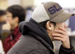 FILE - Young Japanese people search for jobs at an employment agency in Tokyo February 25, 2005.