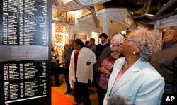 In this Nov. 10, 2017 image, Ellie Dahmer, foreground, wife of Vernon Dahmer of Hattiesburg, who was killed in 1966 by the Ku Klux Klan, their daughter Bettie Dahmer, and an older brother Harold, right at the Mississippi Civil Rights Museum.